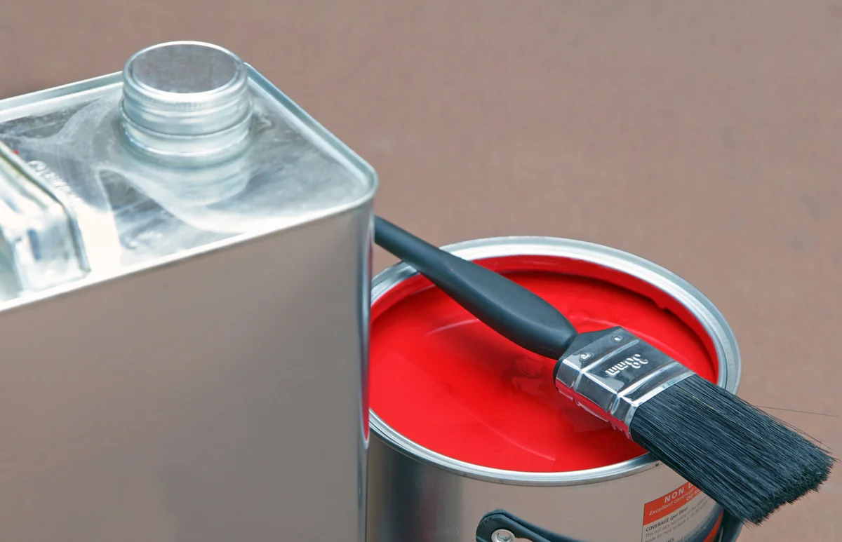 open tin of paint and cleaning solvent