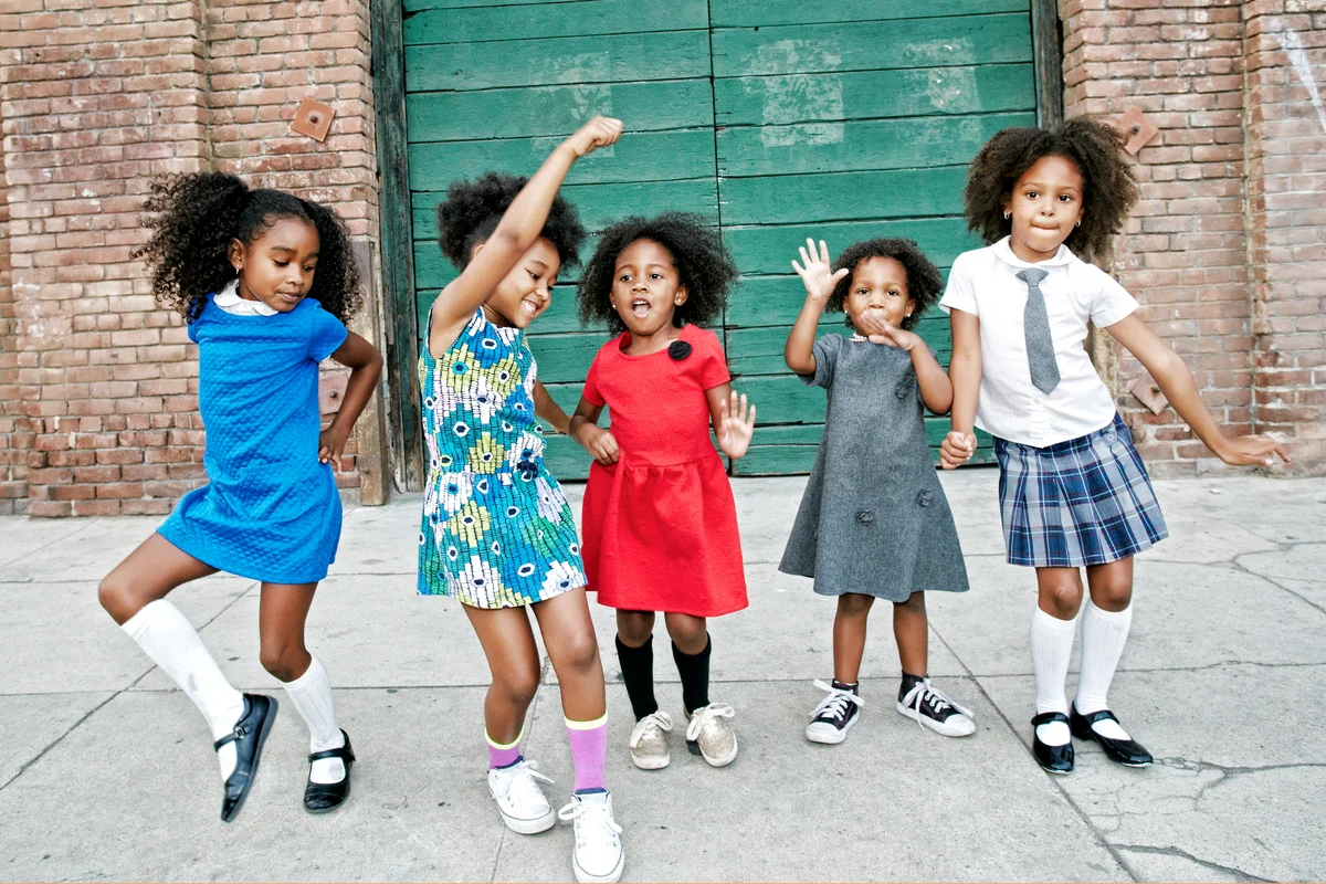 Girls dancing on city sidewalk