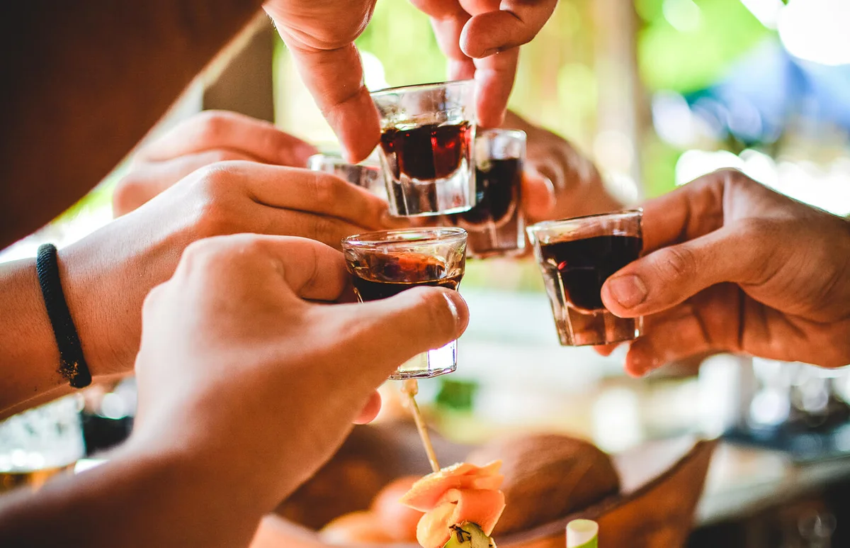 Close-Up Of Hands Doing Shots