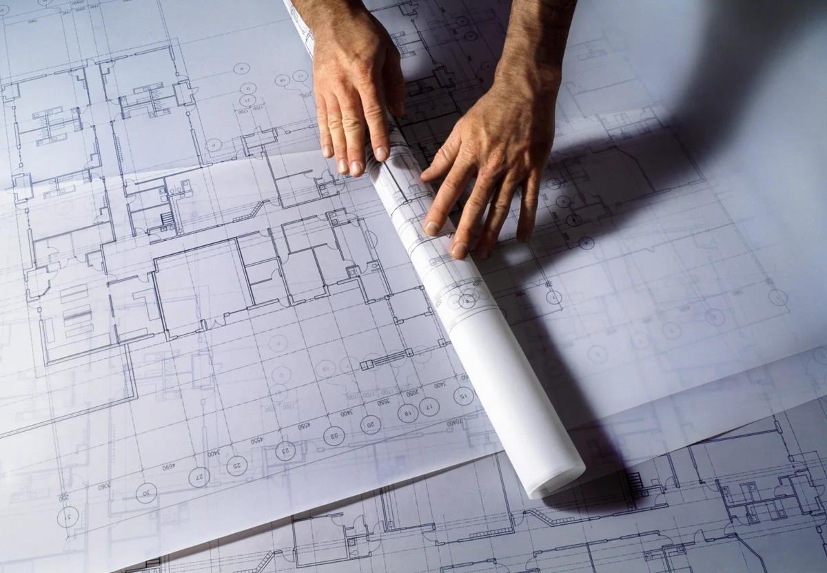 Man unrolling blueprints