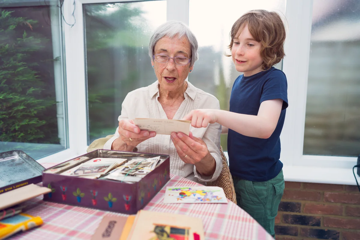 Grandmother and grandson selecting items for a time capsule