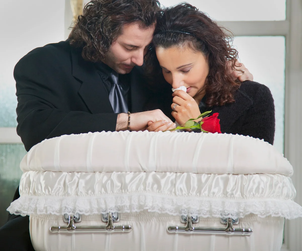 Parents grieving over infant casket
