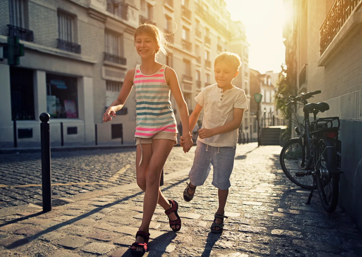 Children running down a French street