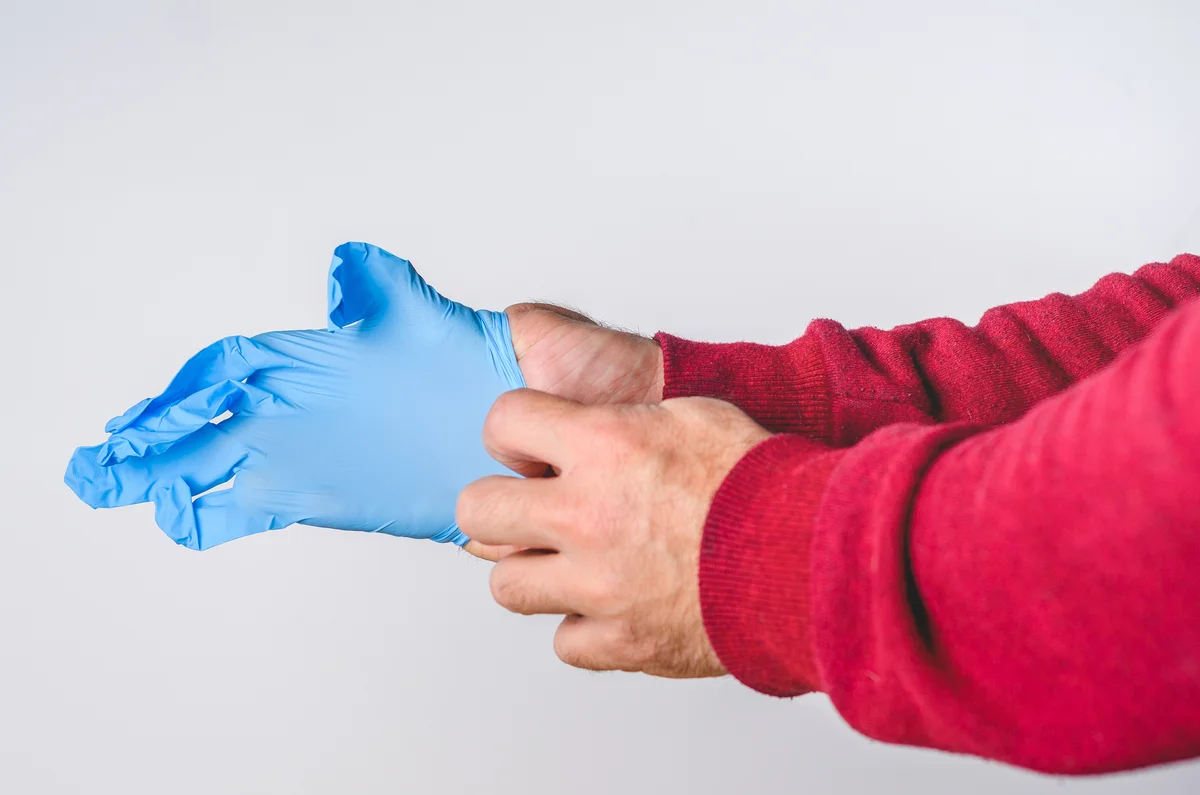 Man putting on medical gloves