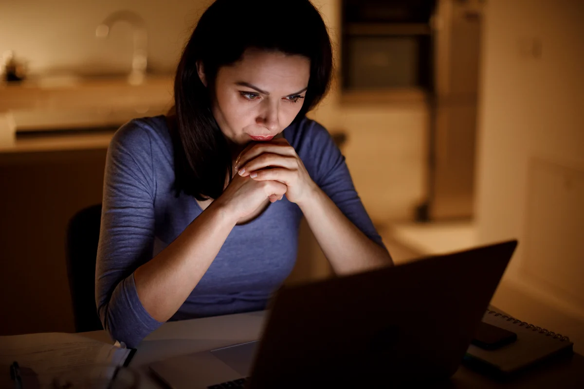 Woman contemplating computer screen