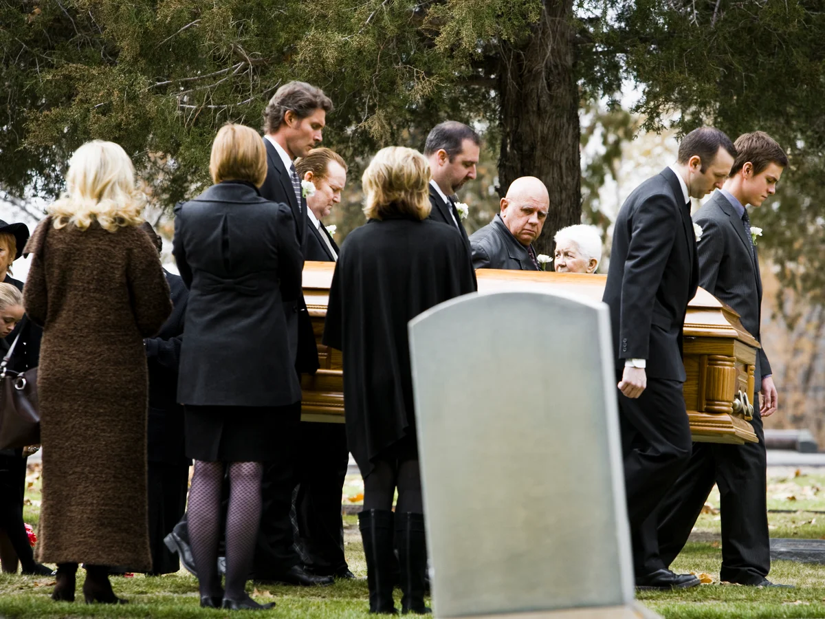 Pallbearers carrying casket to gravesite
