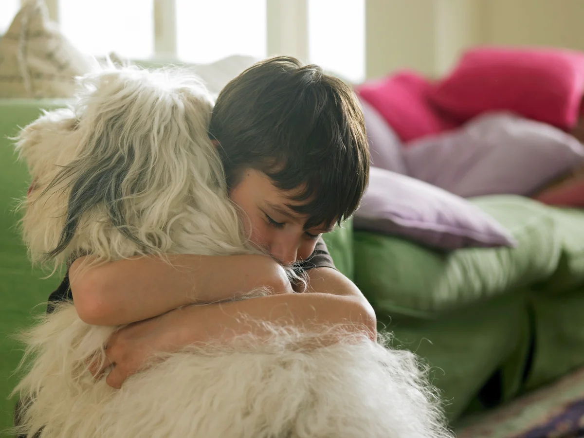 Boy hugging pet dog