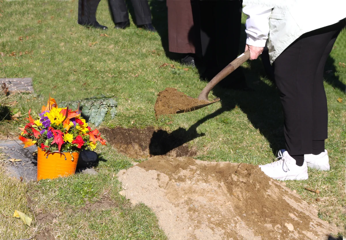 Burying cremation ashes at gravesite