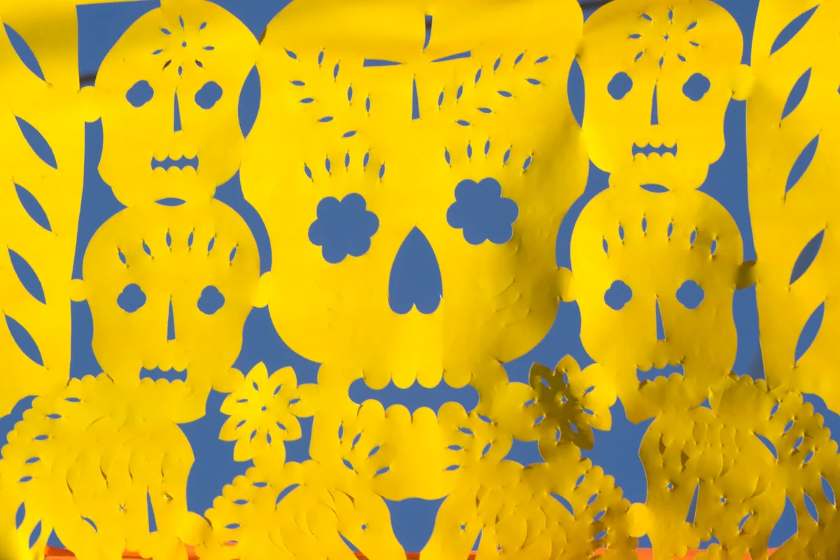Yellow paper cutouts in shape of skulls for Day of the Dead celebration