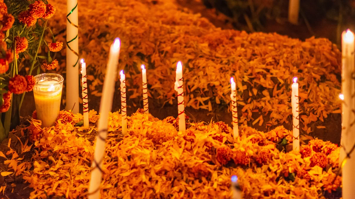 Orange flowers and candles decorate gravesites