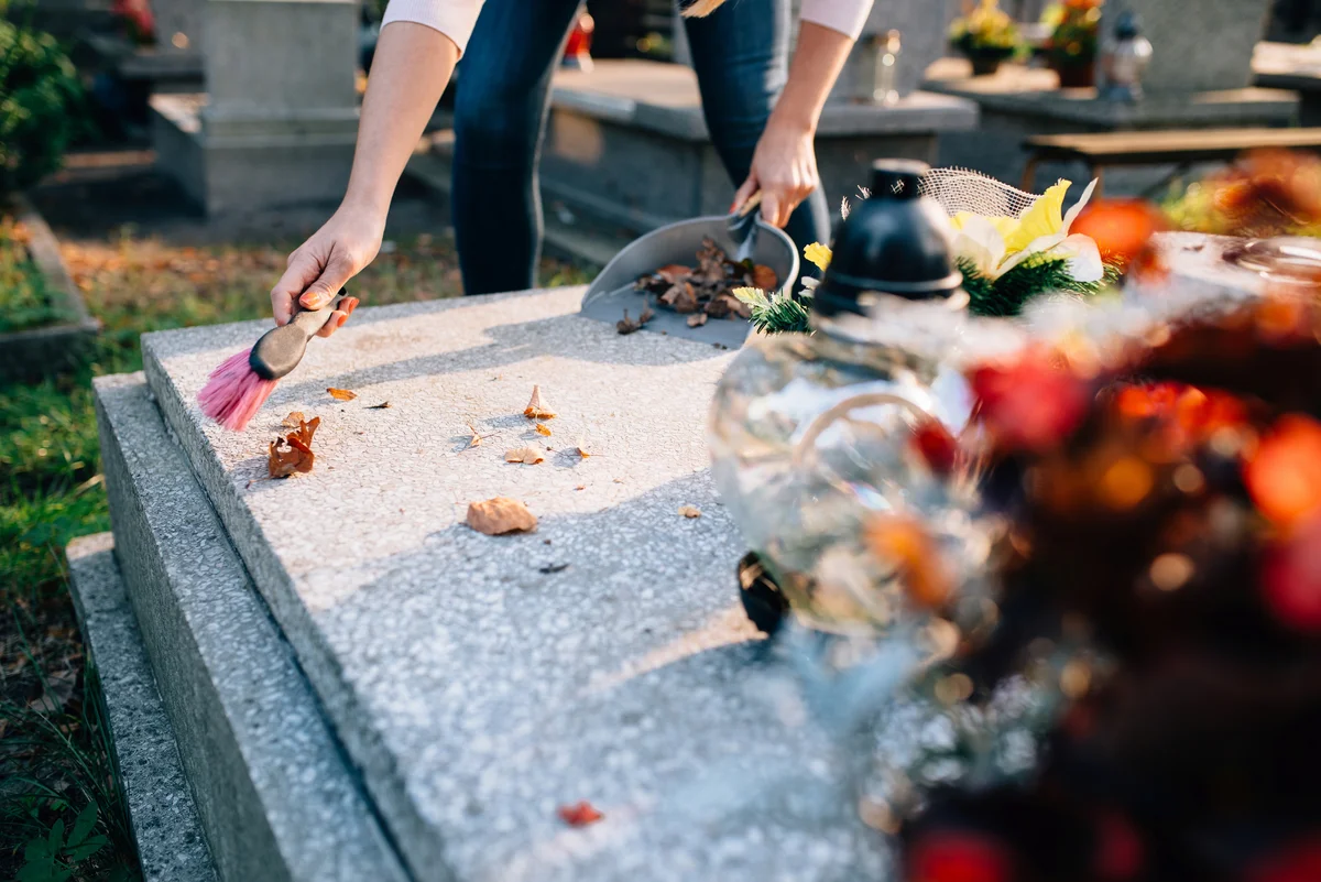 Woman cleaning gravestone