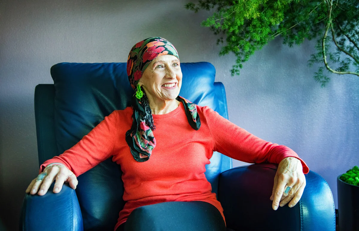 Vibrant senior woman wearing a head scarf smiling in her living room