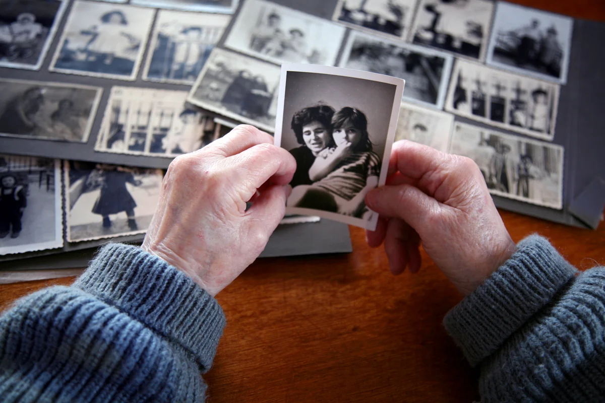 Elderly woman hands holding an old picture