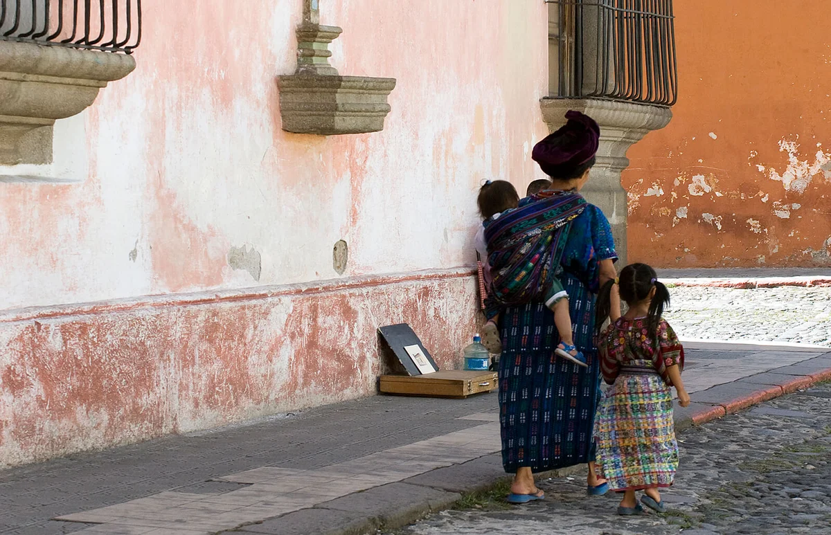 Traditional Mayan mother and children walking on cobbled street