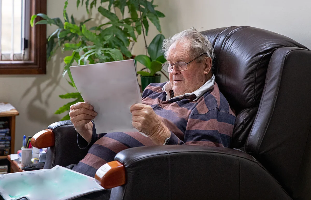 Senior man sitting in his recliner whilst reading the newspaper