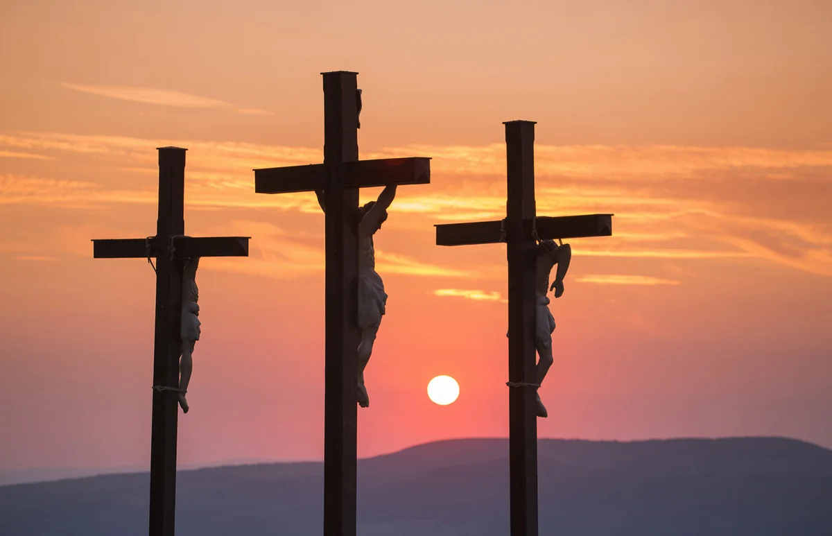 Summit cross on Kreuzberg mountain at sunset