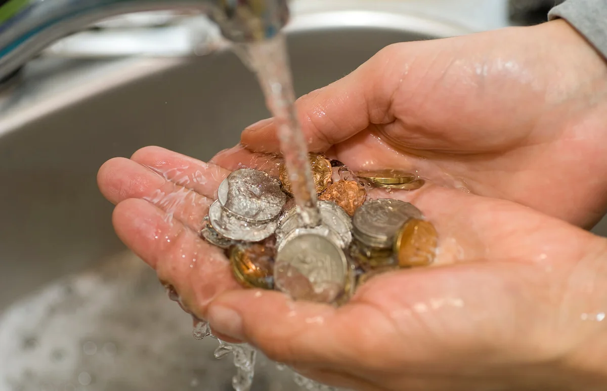 money laundering coins in sink with water