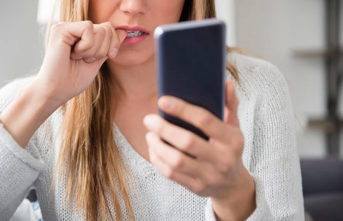 Nervous young woman using smart phone