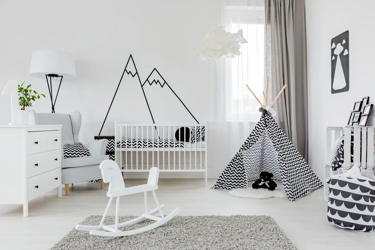 Child room with white furniture, carpet, tent and mountain wall sticker