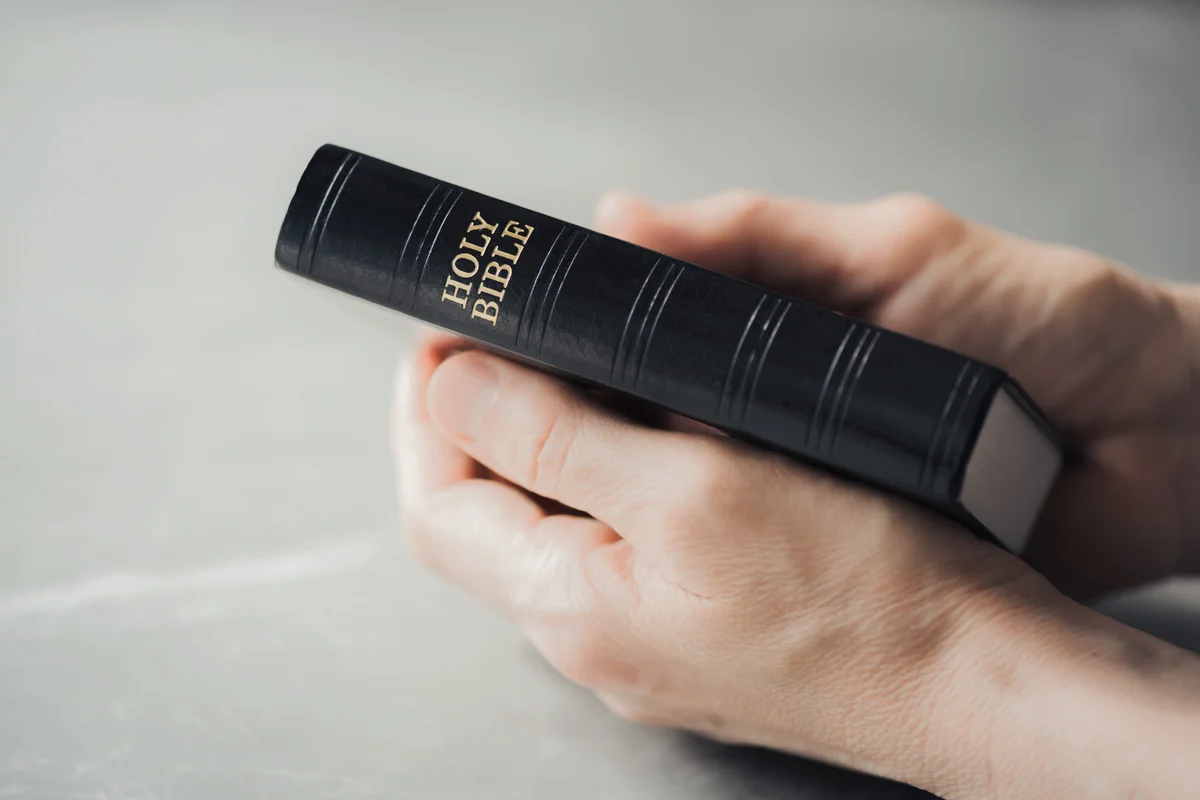 Hand holding Holy Bible