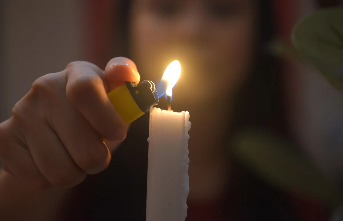 Woman Burning Candle With Lighter