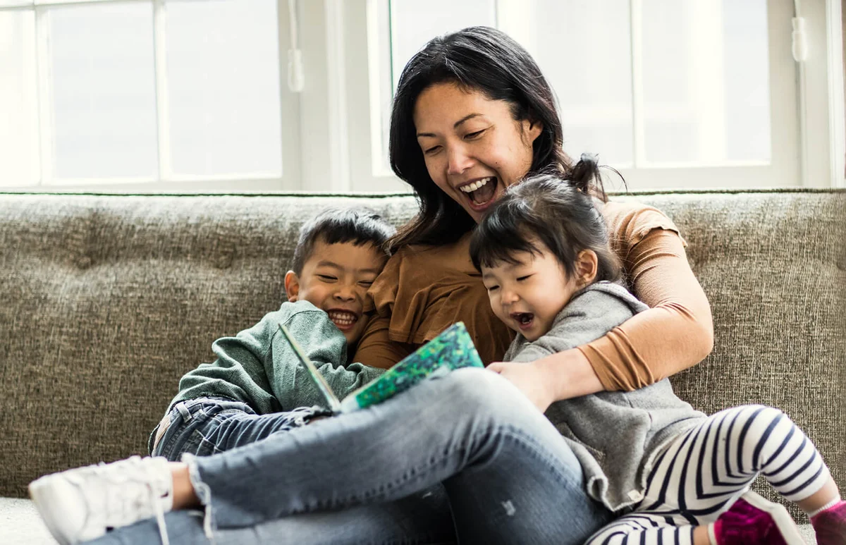 Mother reading to kids on couch