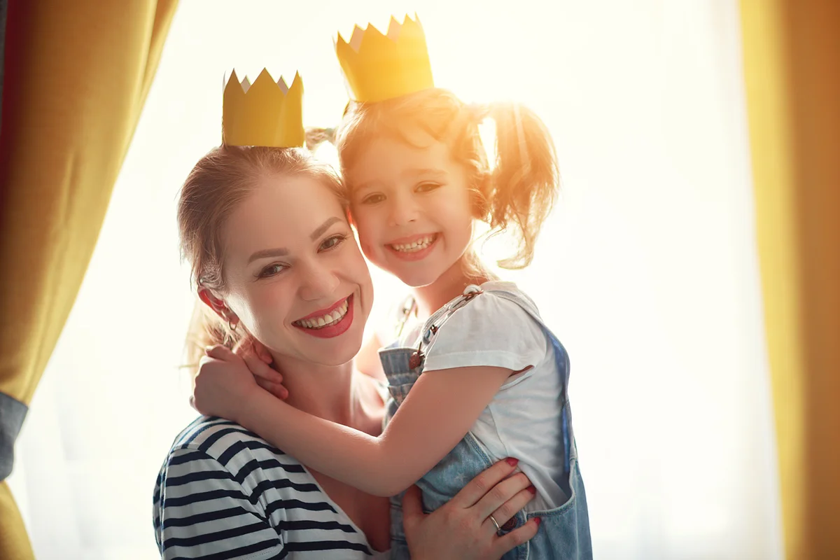 Mother and child daughter wearing crowns