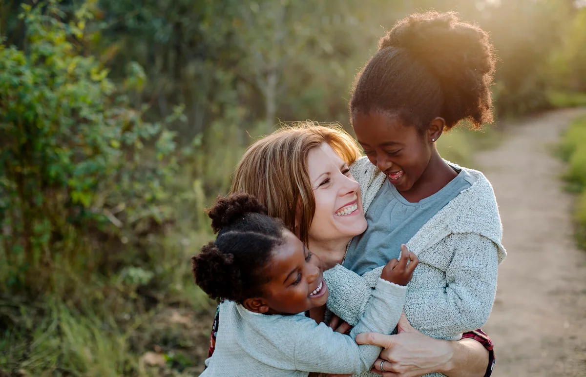 Cheerful mother with daughters at park