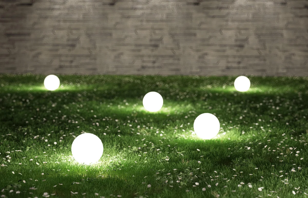 Illuminated Lamps On Grassy Field In Garden