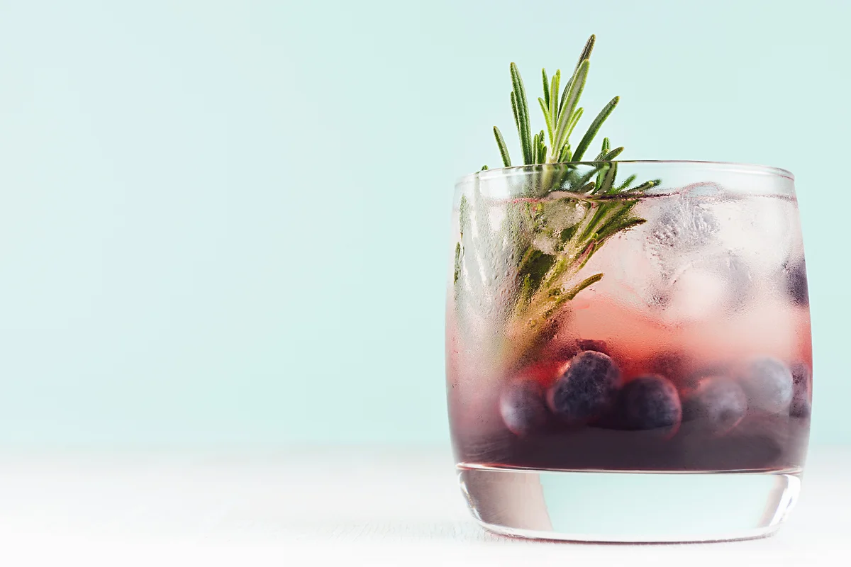 Summer fresh blueberry mocktail in glass with blueberries, ice cubes and rosemary