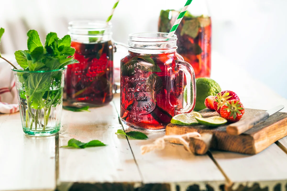 Iced tea with fruits, hibiscus, strawberries, mint and limes
