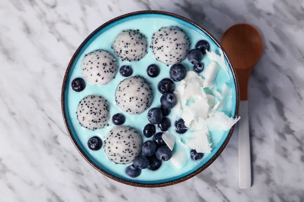 Blue smoothie bowl with grated coconut, blueberries