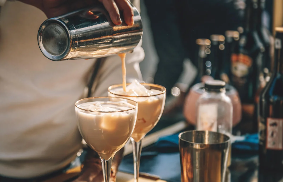 Bartender preparing Irish Cream Liqueur cocktail with shaker