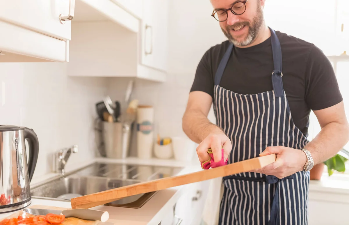 Man cleaning chopping board in the kitchen