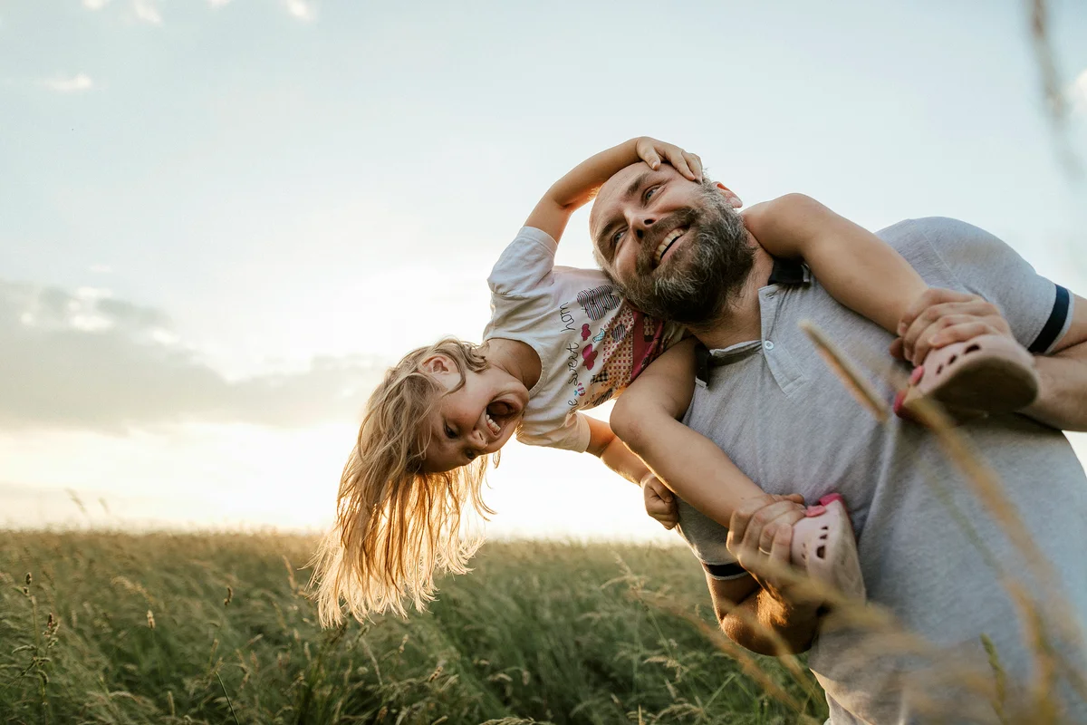 Man playing with his little daughter in nature
