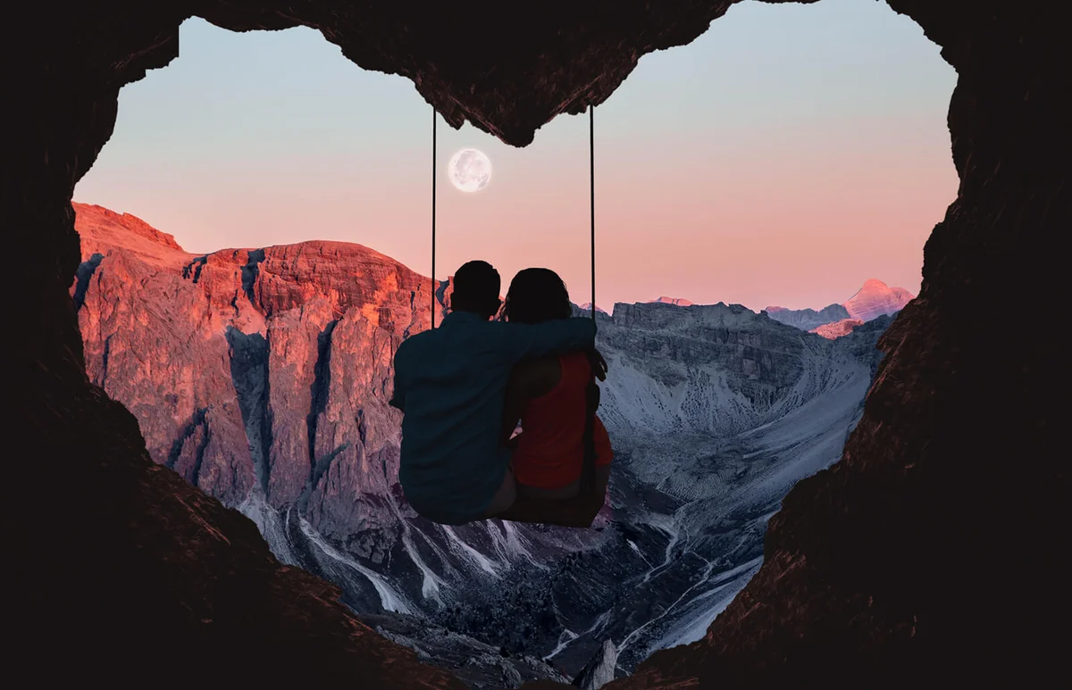Couple on swing contemplating the mountains
