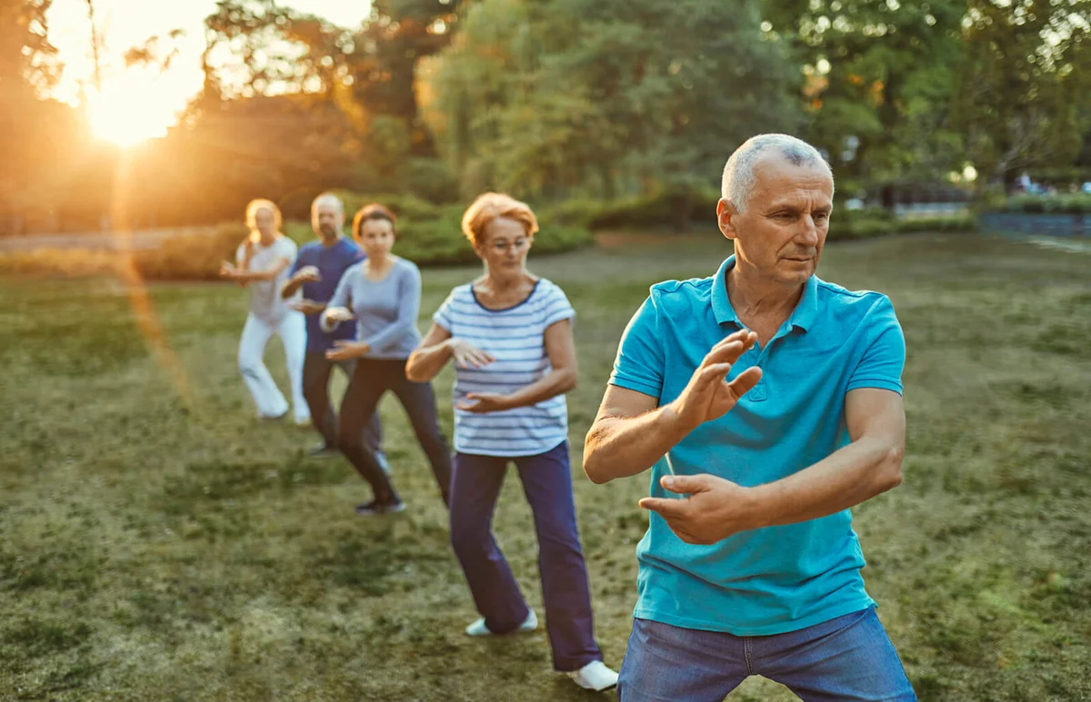 Group of people doing Tai chi in a park