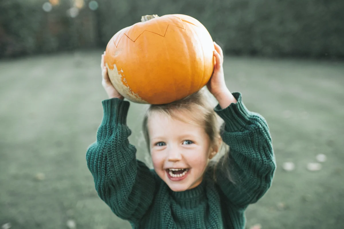 Child holding a pumpkin