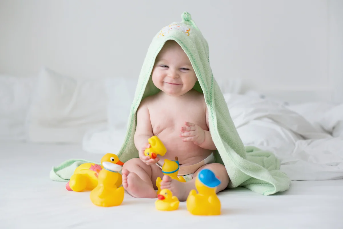 Cute little baby toddler boy playing with rubber ducks