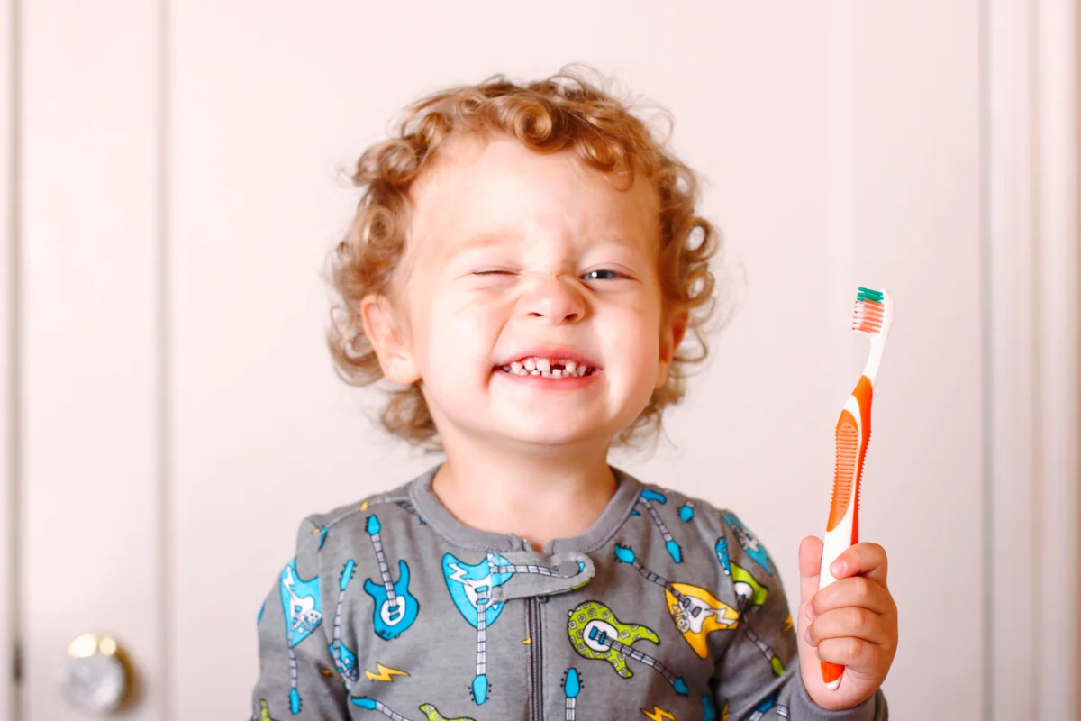 Toddler in his pajamas brushing his teeth