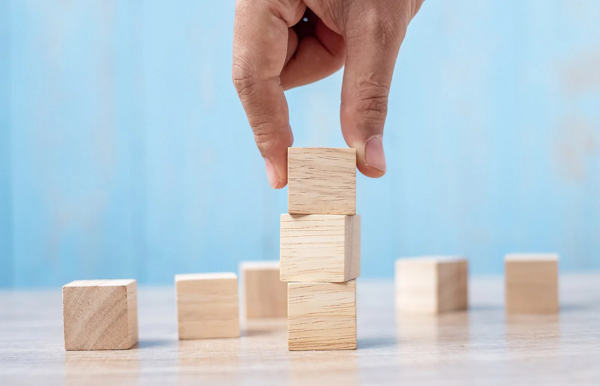 Hand Stacking Wooden Blocks On Table