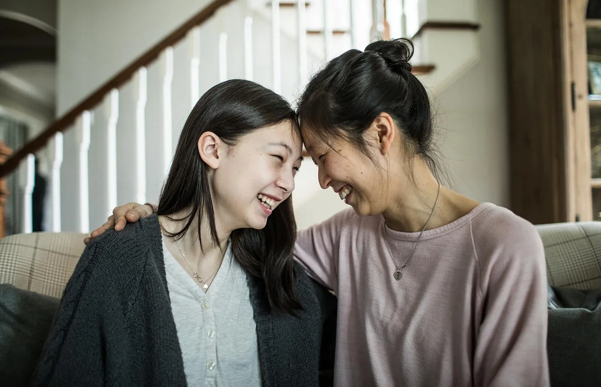 Mother and teenage daughter talking at home
