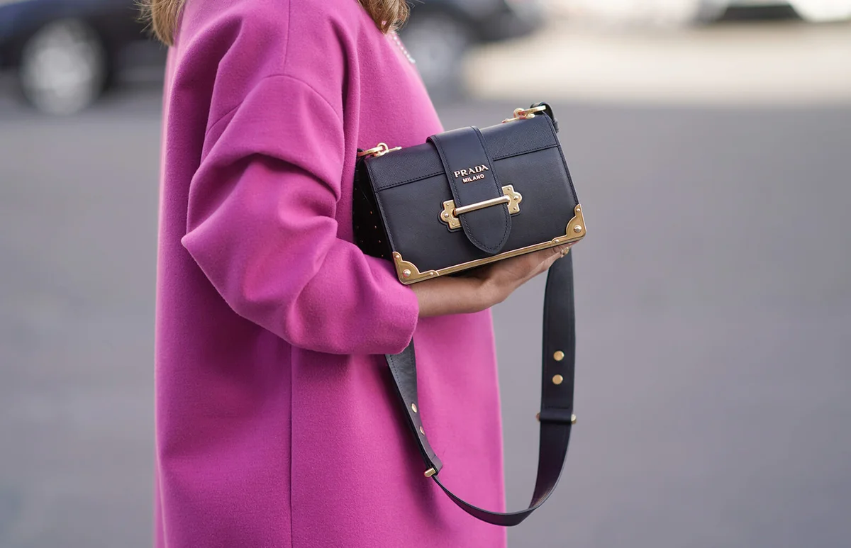 A guest wears a pink coat and a Prada bag, during Paris Fashion Week Womenswear Fall/Winter 2018/2019, on March 3, 2018 in Paris, France. | Getty Editorial Use