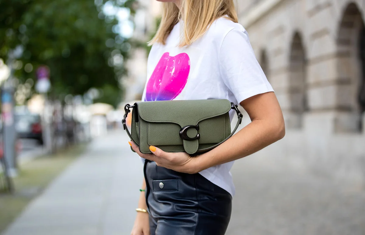 Sonia Lyson is seen total look Coach: leather pants, white tshirt with print, green bag, sunglasses Bottega Veneta, New Balance sneaker on July 28, 2020 in Berlin, Germany | Getty Editorial Use