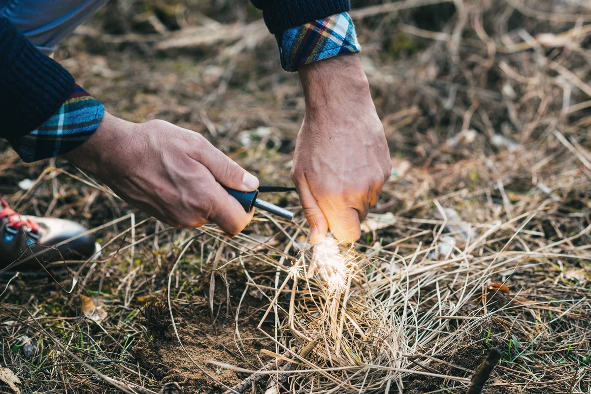 A man makes a fire with a flint