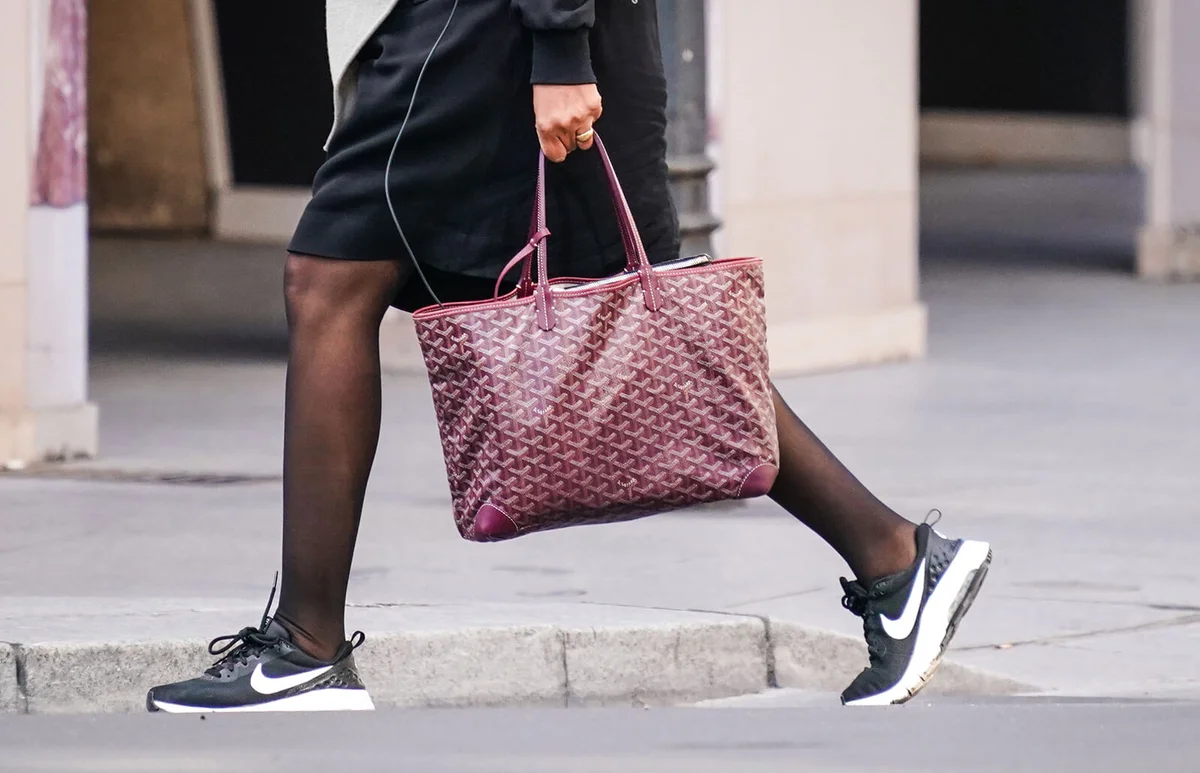 passerby wears a purple Goyard bag, black Nike sneakers, in the streets of Paris, on May 14, 2020 in Paris, France | Getty Editorial Use