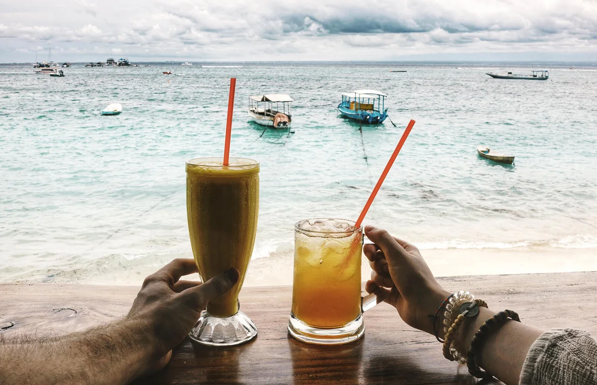 Cropped Image Of Hands With Drinks At Beach