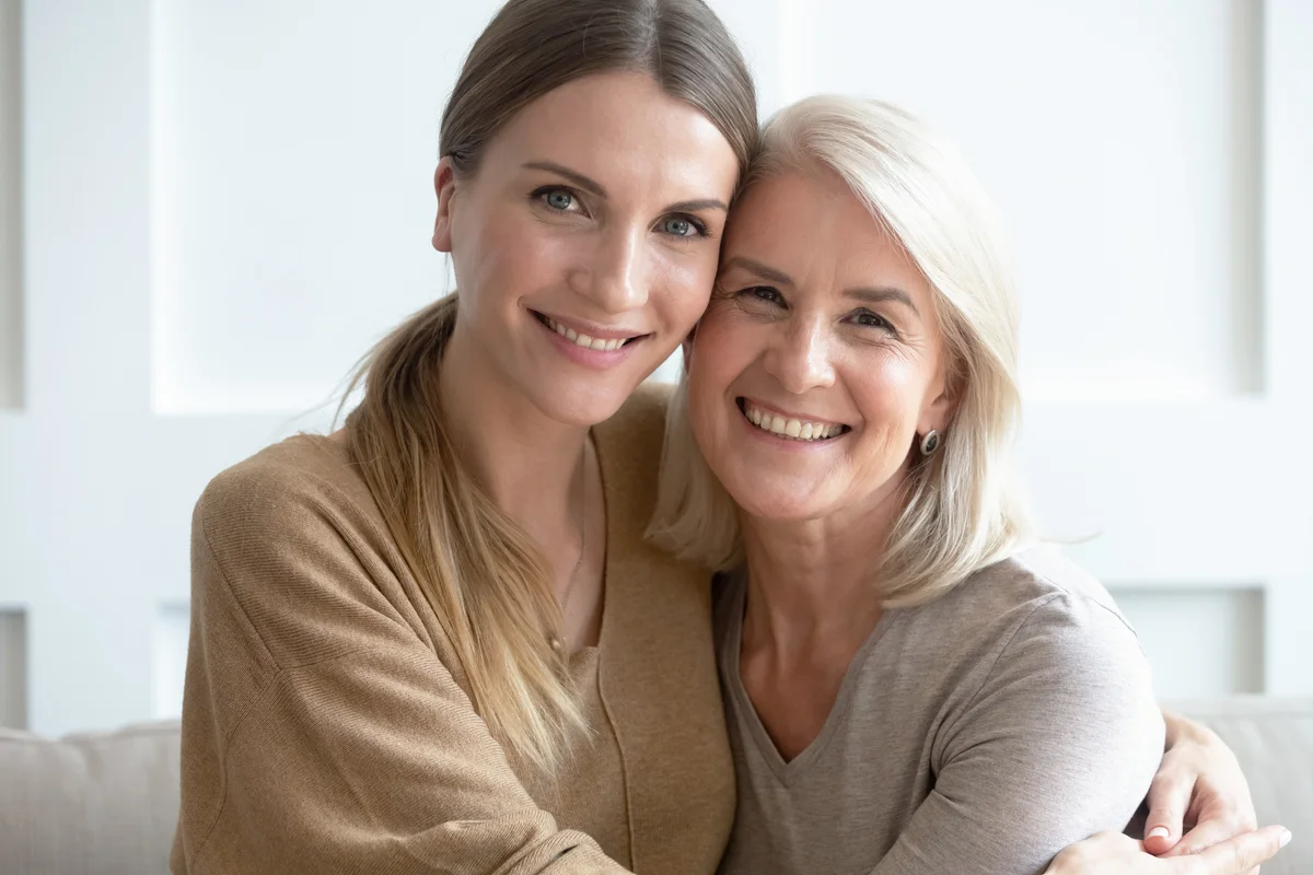 Aged mother and adult daughter hugging