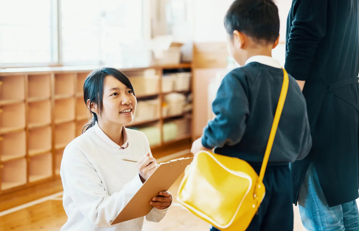 Mother dropping off young son at preschool