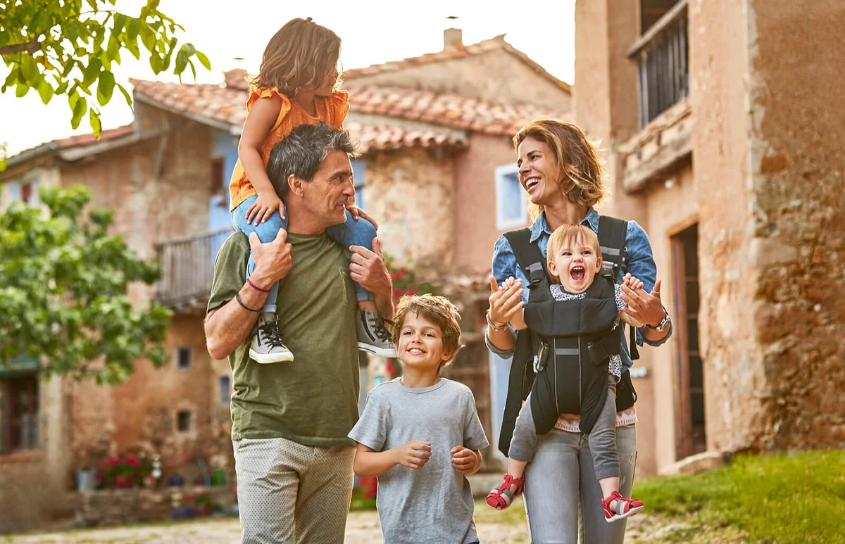 Happy parents carrying children in back yard